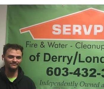 Tyler McWalter standing in front of Servpro banner.
