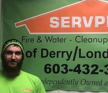 DJ McCord standing in front of Servpro banner.